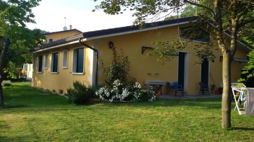 una casa amarilla con un patio delante en Agriturismo Il Lago, en Arcugnano