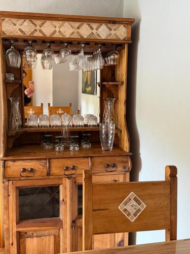 a wooden dresser with a mirror with glasses on it at EifelFein in Niederstadtfeld