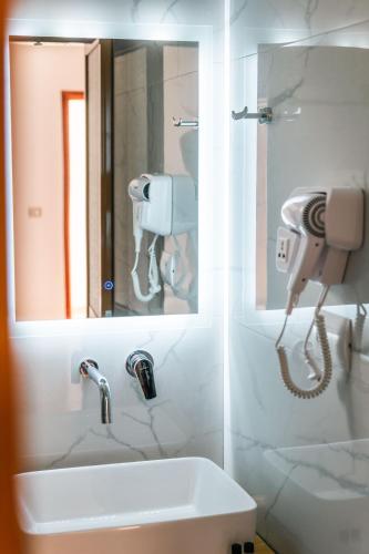 a bathroom with a sink and a phone on the wall at Vila Malo in Ksamil