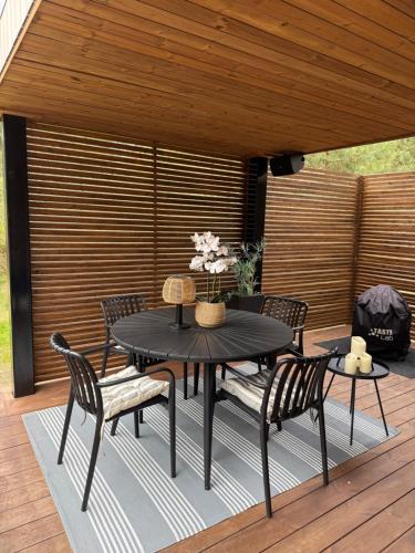 a black table and chairs on a wooden deck at Luxury Tahkuranna SPA villa Pärnu in Laadi