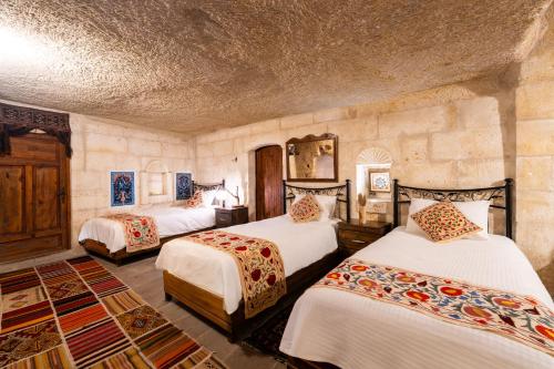 a bedroom with three beds in a room at Tulip Cave Suites in Göreme