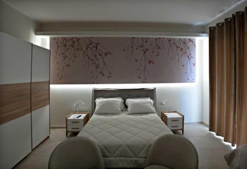 ein Schlafzimmer mit einem Bett und einem großen Gemälde an der Wand in der Unterkunft Max's Rooms in Termoli