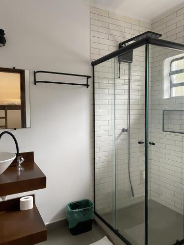 a bathroom with a glass shower with a sink at Savannah Pousada in São Paulo