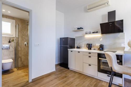 a kitchen with white cabinets and a sink at Kastri Houses in Panormos Skopelos