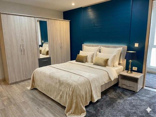 a bedroom with a large bed with a blue wall at Flat,App,Sea side,Stay Sousse 2-Bedroom in Sousse