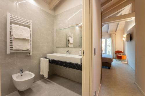 a white bathroom with a sink and a toilet at Hotel Vittorio in Desenzano del Garda