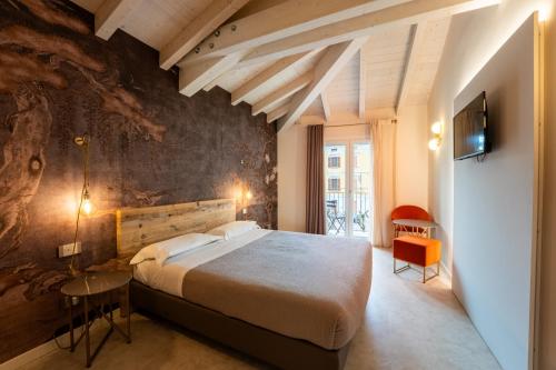 a bedroom with a large bed and a wall at Hotel Vittorio in Desenzano del Garda