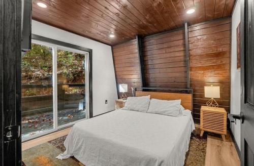a bedroom with a bed and a large window at Soakin Up The Views in Gatlinburg