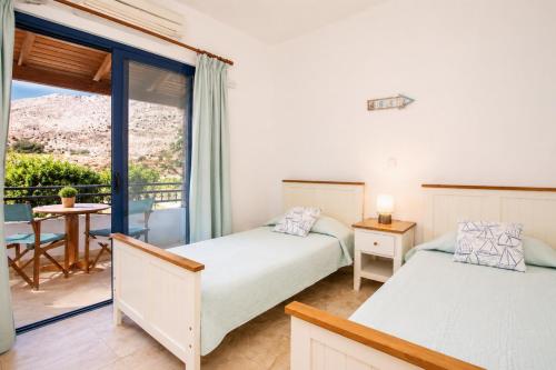 a bedroom with two beds and a balcony at Villa Driftwood in Rhodes Town