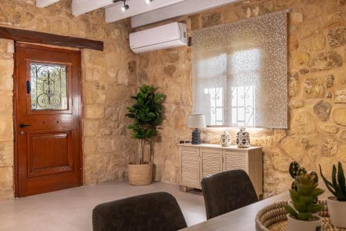 a room with a wooden door and a table and chairs at Artemis Luxury Villa in Méson Yerakaríon