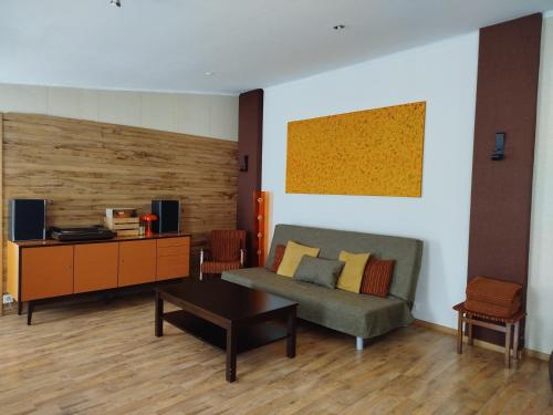 a living room with a couch and a table at Zaļais namiņš in Ventspils