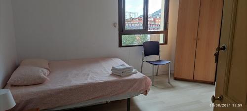 a small bedroom with a bed and a window at Bilbao Habitaciones in Bilbao