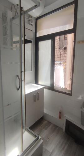 a bathroom with a shower and a sink and a window at Bilbao Habitaciones in Bilbao