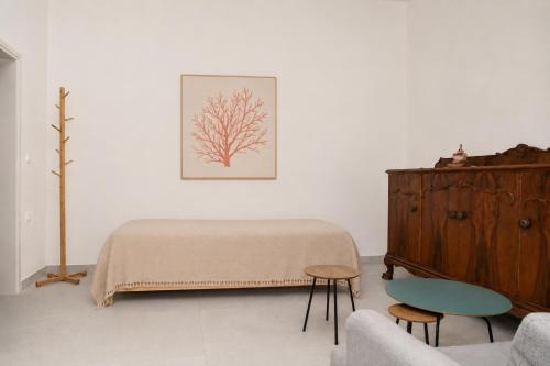 a living room with a bed and a wooden dresser at Mirtilo - Local Style, 1 Min from Main Beach in Kardamaina