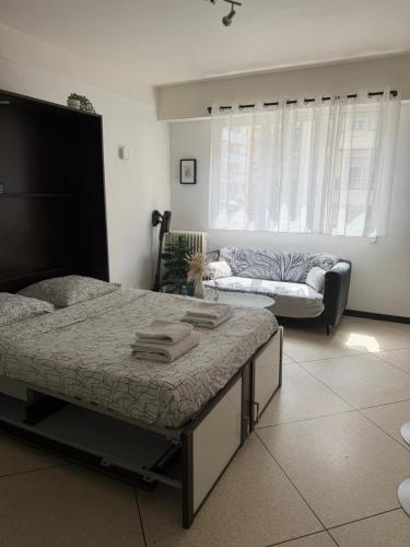 a bedroom with two beds and a couch in it at Studio lumineux avec balcon à Nice in Nice