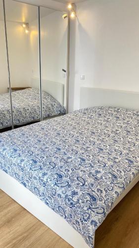 a bedroom with two beds with blue and white sheets at Casa do Henri in Corvo