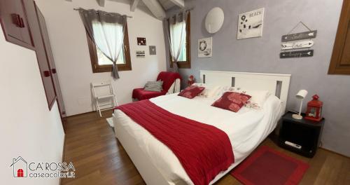 a bedroom with a large bed with a red blanket at Ca' Rossa Lido Venezia in Mestre