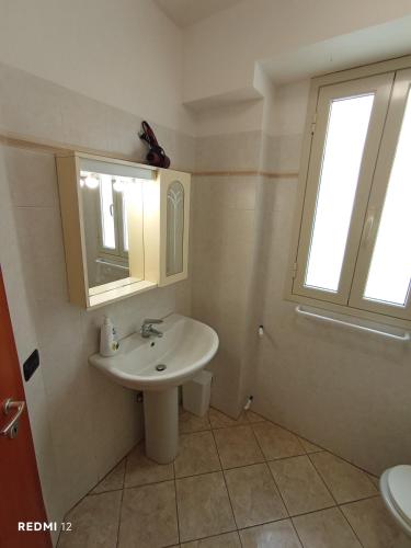 a bathroom with a sink and a mirror and a window at Alba Blu Sampieri in Sampieri