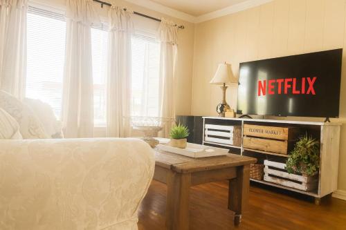 a bedroom with a bed and a tv and a table at Cozy Cottage Centrally Located WorkerFriendly in Sherman