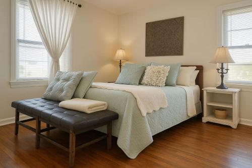 a bedroom with a bed and a chair and windows at Cozy Cottage Centrally Located WorkerFriendly in Sherman
