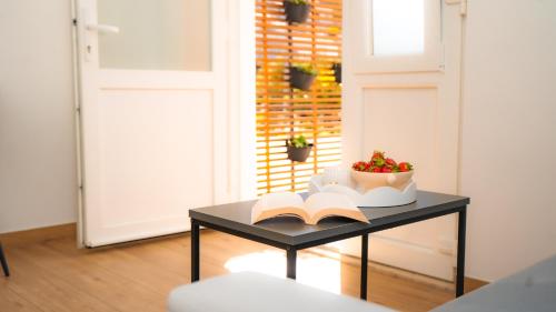 a table with an open book and a bowl of fruit at Apartment Eva Hvar in Hvar