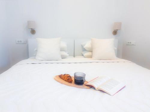 a plate of food and a book and a cup on a bed at Apartment Eva Hvar in Hvar