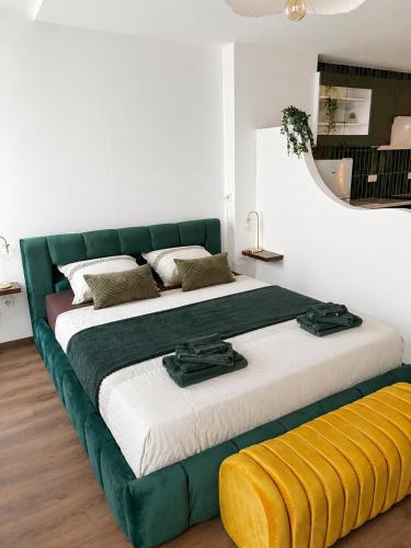 a large bed in a room with a green couch at Studio chic et confortable in Lorgues
