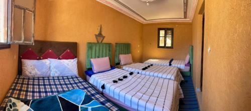 a room with three beds in a room at Gite Dar Tanzoughte in Imlil
