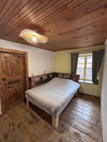a bedroom with a bed and a wooden ceiling at Comme à La Maison in Cayres