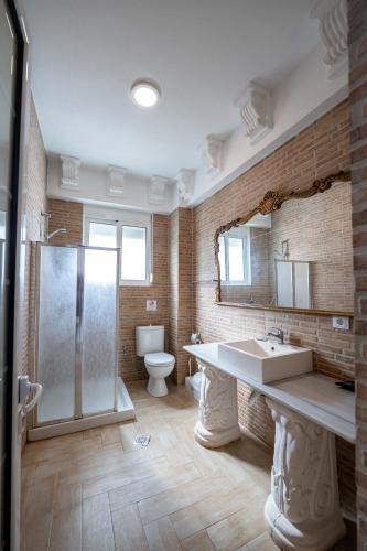 a bathroom with a sink and a shower and a toilet at León Hotel Saranda in Sarandë