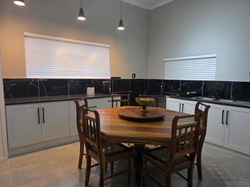 a kitchen with a wooden table and chairs at 5Res Stay in Queenstown
