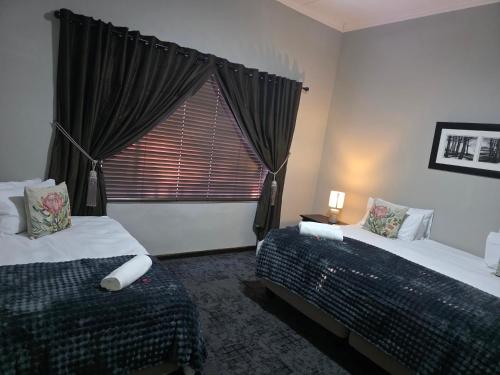 a bedroom with two beds and a large window at 5Res Stay in Queenstown