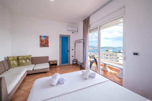 a living room with a bed and a couch at León Hotel Saranda in Sarandë