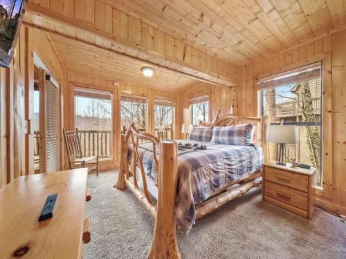 a bedroom with a bed and a desk and windows at Eden's View in Gatlinburg