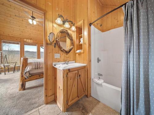 a bathroom with a sink and a tub and a mirror at Eden's View in Gatlinburg