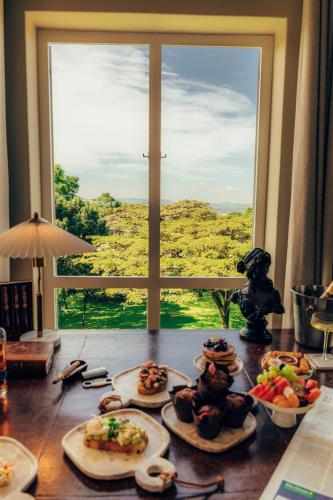 a table with plates of food on it with a window at Redlands Hotel in Pietermaritzburg