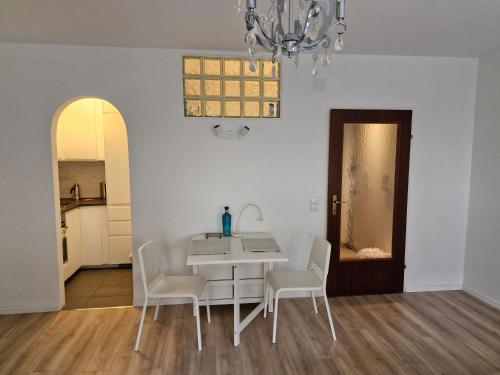 a dining room with a white table and chairs at Sleep - See - Nah in Klagenfurt