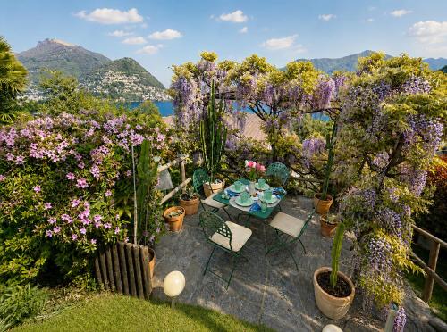 a garden with a table and chairs and flowers at Lake View Palm Garden in Lugano