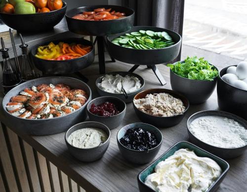 a table topped with bowls of different types of food at Sand Hotel by Keahotels in Reykjavík