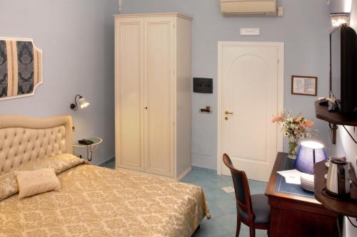 a bedroom with a bed and a desk and a table at Hotel L'Antico Convitto in Amalfi