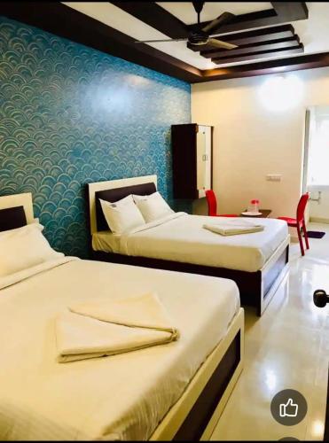 a hotel room with two beds in a room at GURU RESIDENCY yercaud in Yercaud