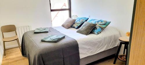 a bed with pillows on it in a room at Le Vivastella in Cucq