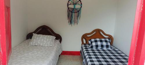 a room with two beds and a pillow and a wall at Finca la pilarica in Istmina