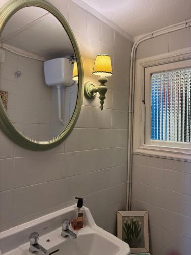 a bathroom with a sink and a mirror at O lar da praia in Corcubión