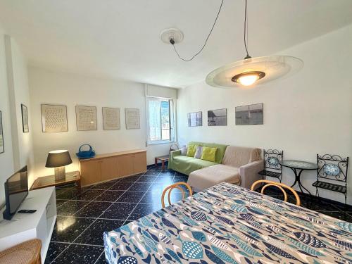 ein Wohnzimmer mit einem Bett, einer Couch und einem Tisch in der Unterkunft Appartamento Roggero in Levanto