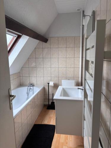 a bathroom with a bath tub and a sink at Le face mer in Le Portel