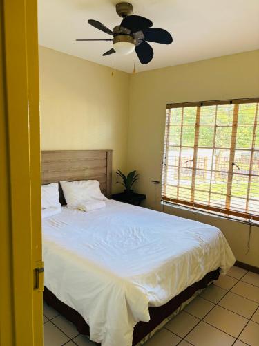 a bedroom with a bed and a ceiling fan at Sleep in Crestwave villas in eMalahleni