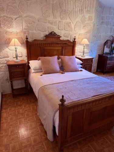 a bedroom with a large wooden bed with two night stands at Reves au Soleil in Thiviers