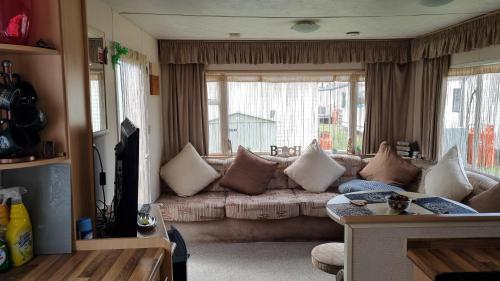 a living room with a couch and a large window at Golden sands 326 3 bedroomed caravan in Ingoldmells