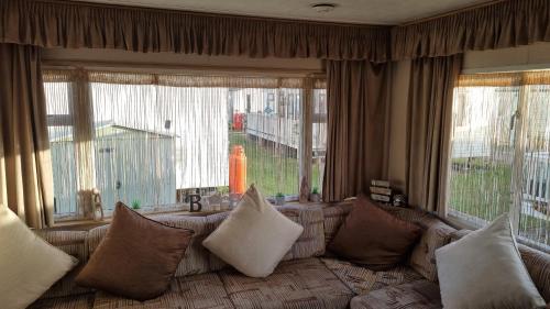 a living room with a couch and large windows at Golden sands 326 3 bedroomed caravan in Ingoldmells